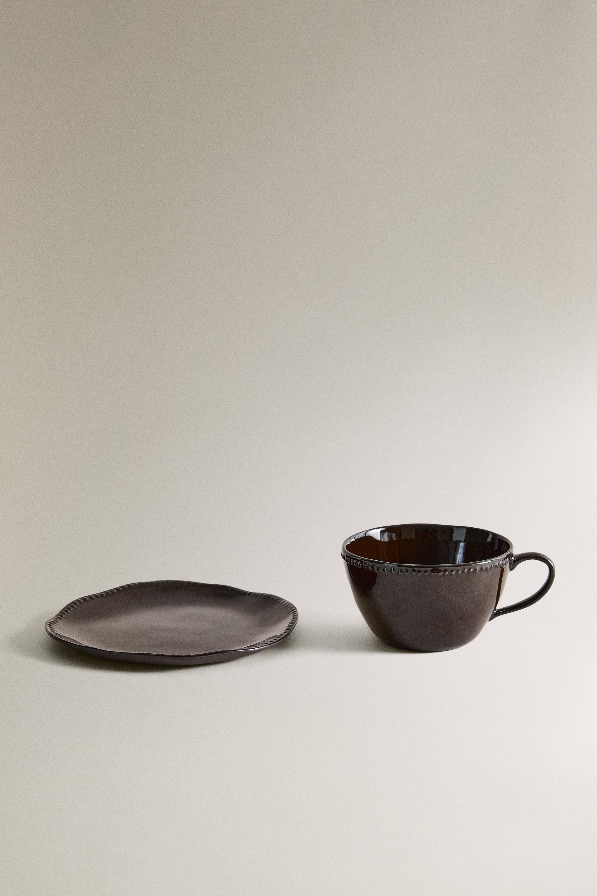 STONEWARE COFFEE CUP AND SAUCER WITH RAISED DESIGN